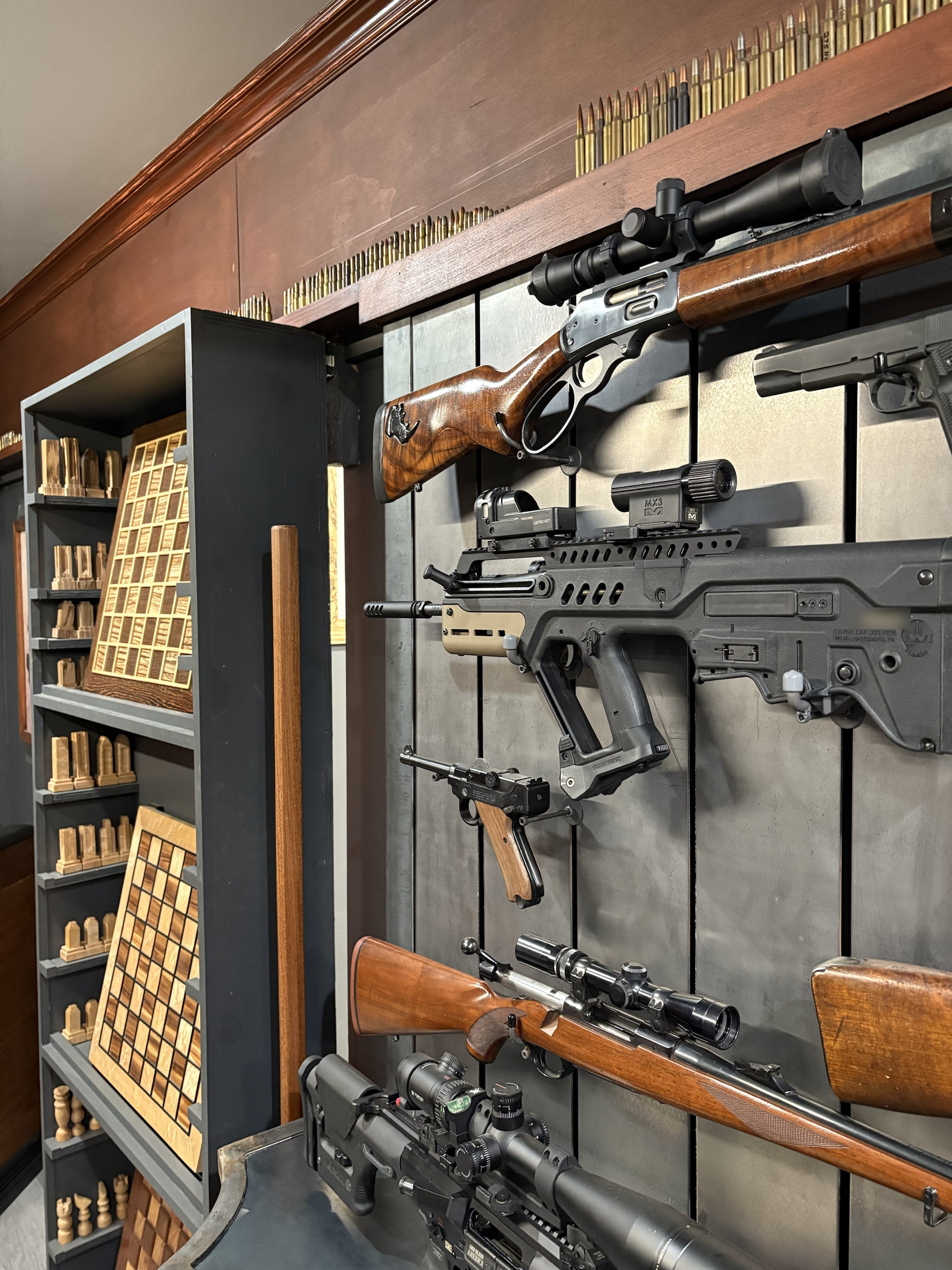 Looking along the steel wall from the side, rifles standing off the panels